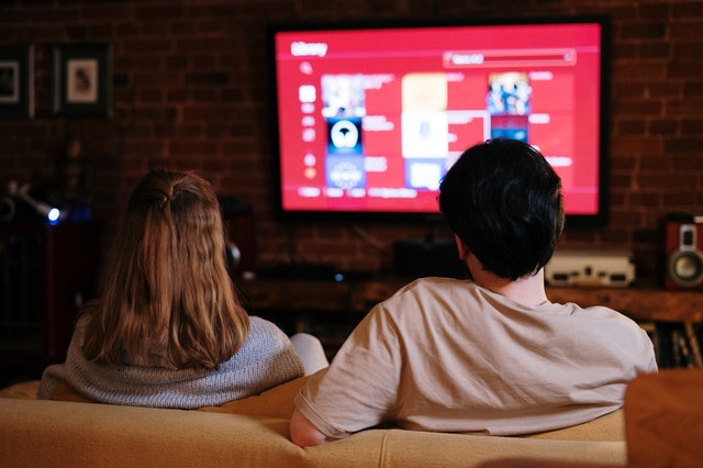a couple watching content recommendations on a TV